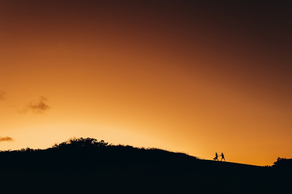 a couple of people standing on top of a hill