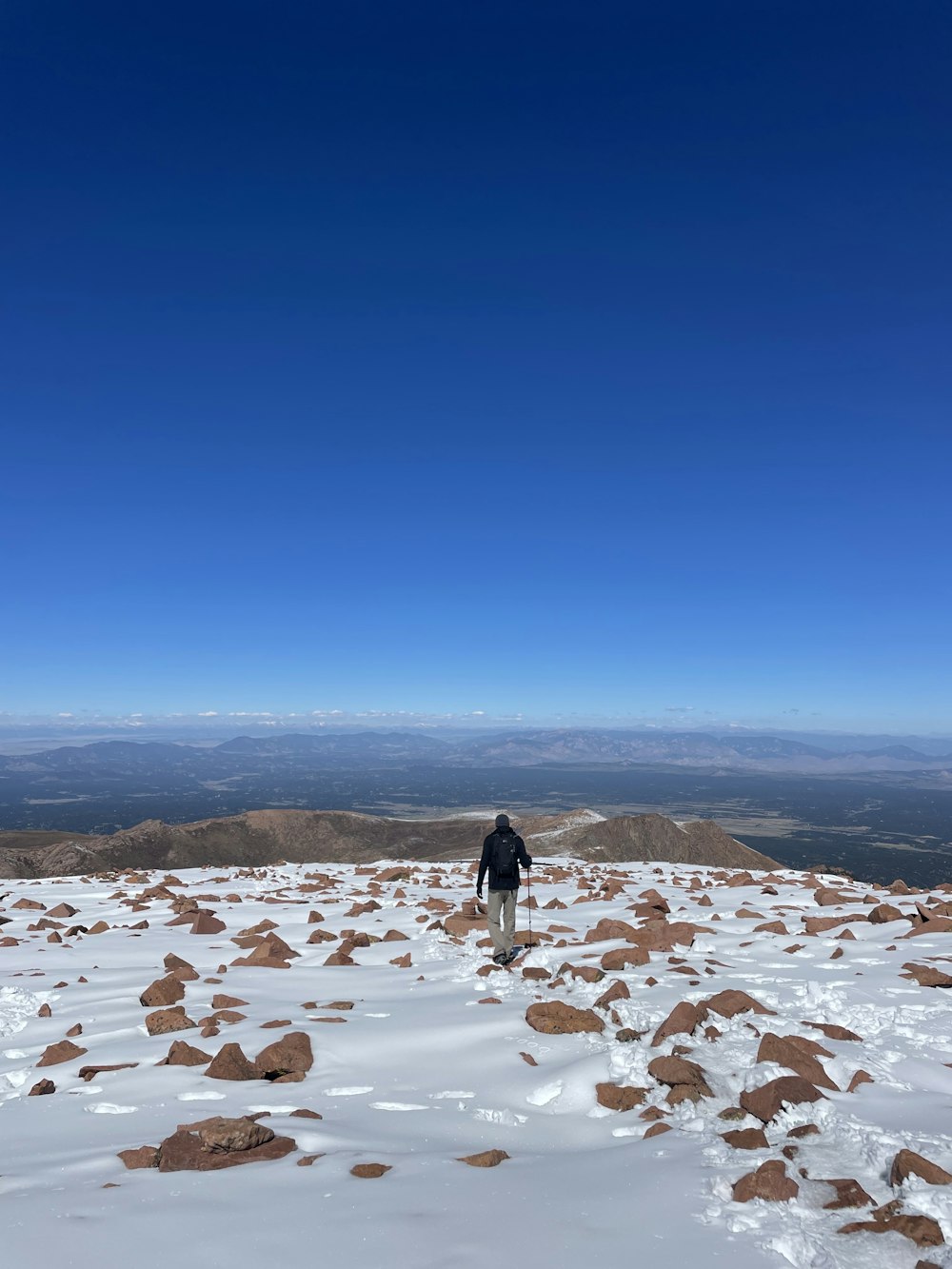 a man standing on top of a snow covered slope