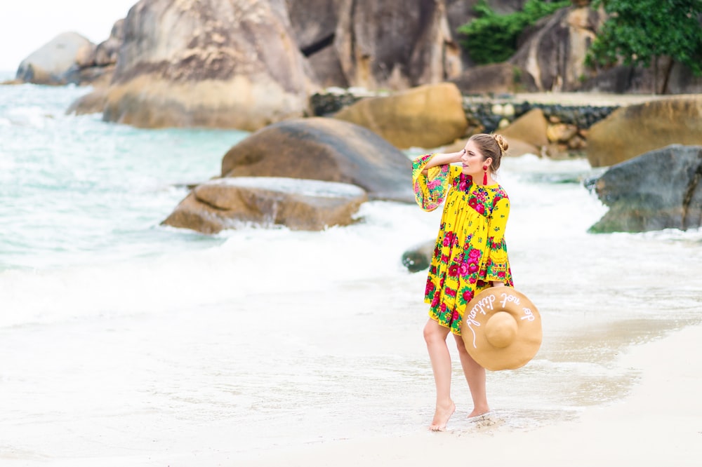 a woman standing on a beach next to the ocean