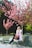 A happy woman wearing a stylish spring outfit in a park.
