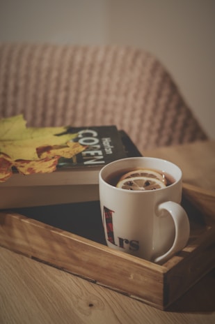 a cup of coffee and a book on a tray