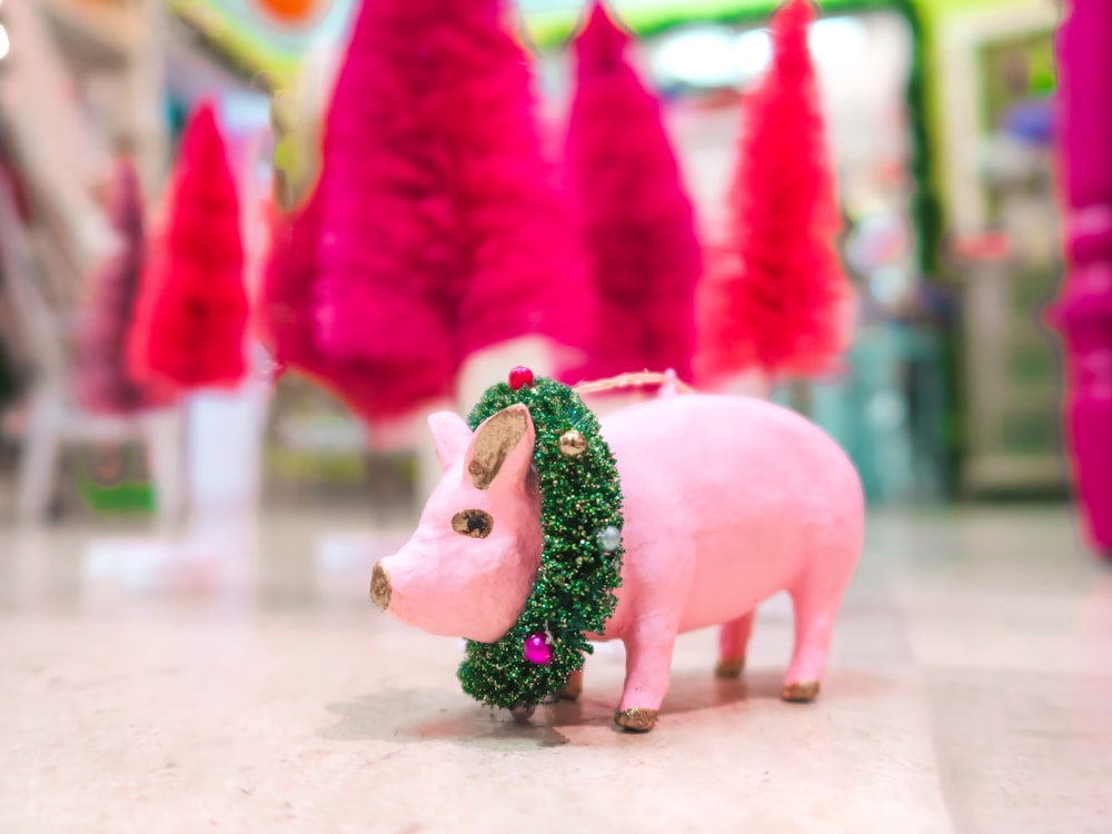 a pink pig with a wreath on its head