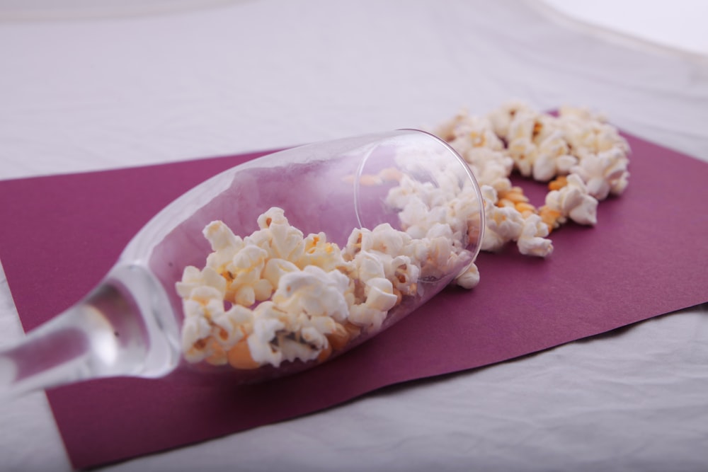 a bottle filled with popcorn sitting on top of a purple mat