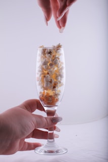 Close-up of hands holding popcorn and drinks during a communal viewing event