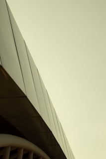 Sleek corporate building exterior with metallic silver and deep navy accents under clear sky.