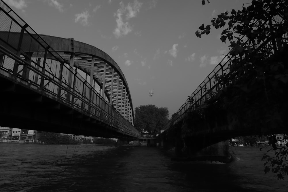 a black and white photo of a bridge over a river