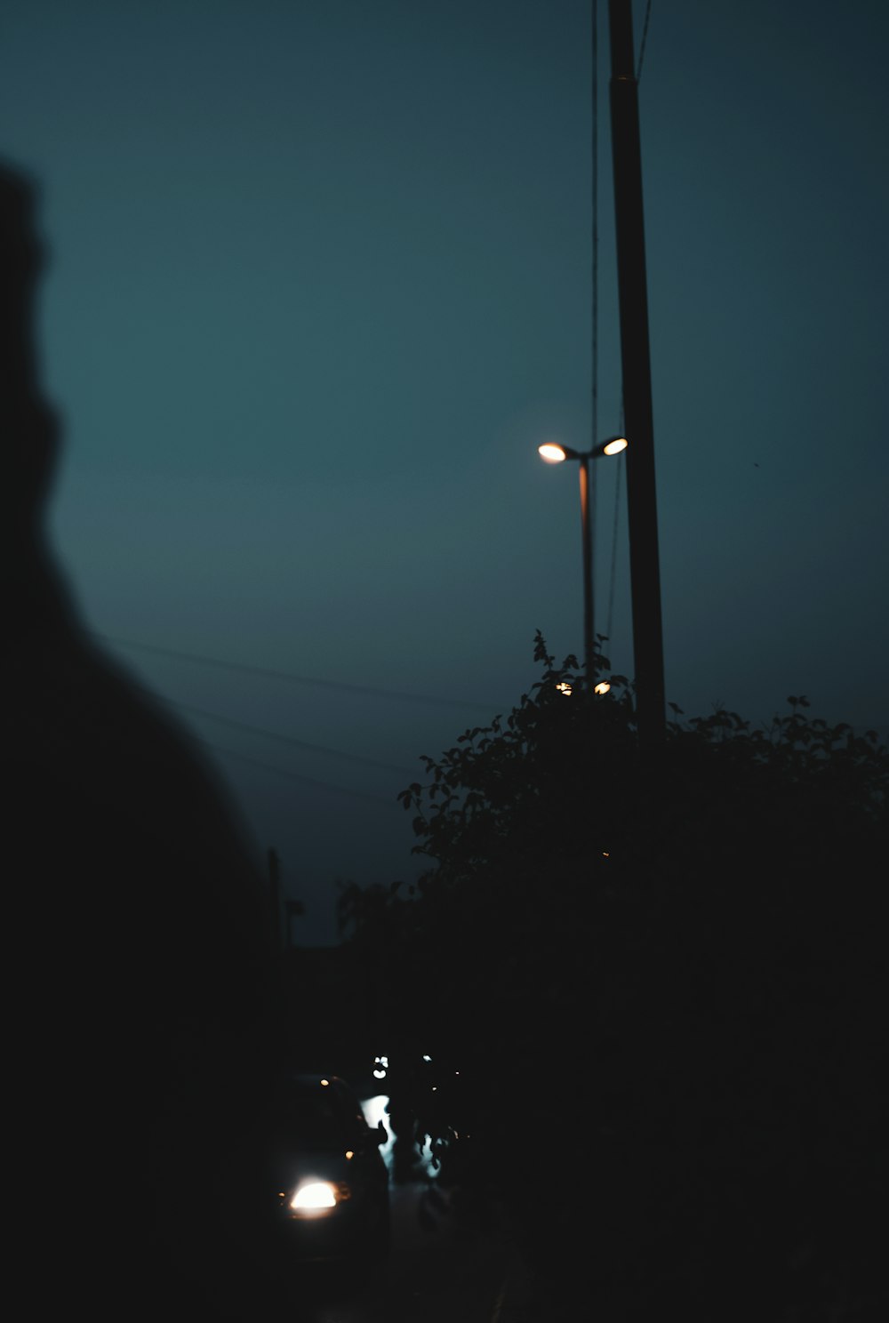 a man standing next to a street light at night