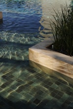 a pool with clear water and a planter