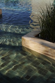 a pool with clear water and a planter