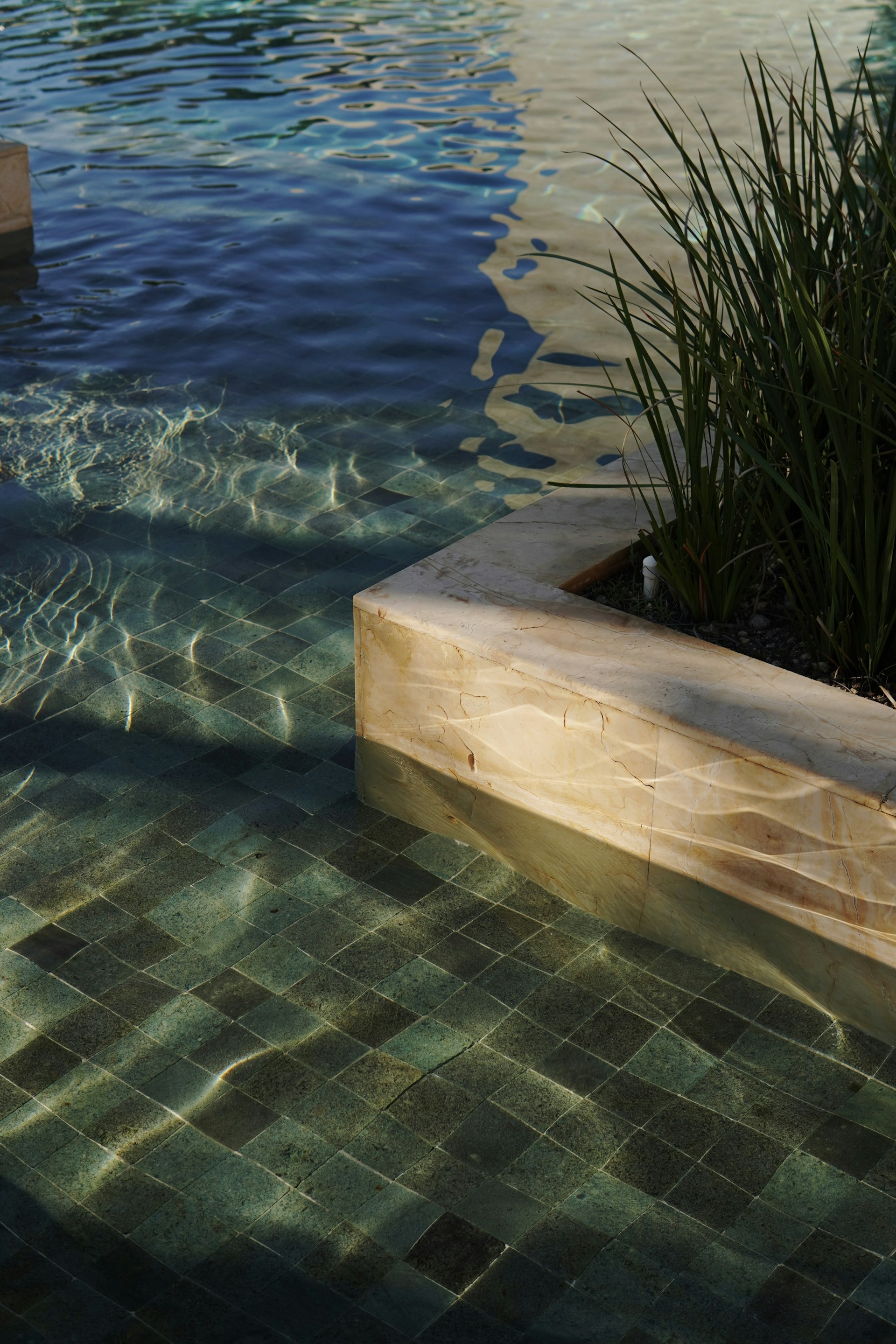 a pool with clear water and a planter
