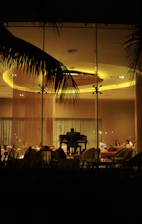 A softly lit hotel lounge with a pianist playing an elegant melody, bathed in warm gold tones.