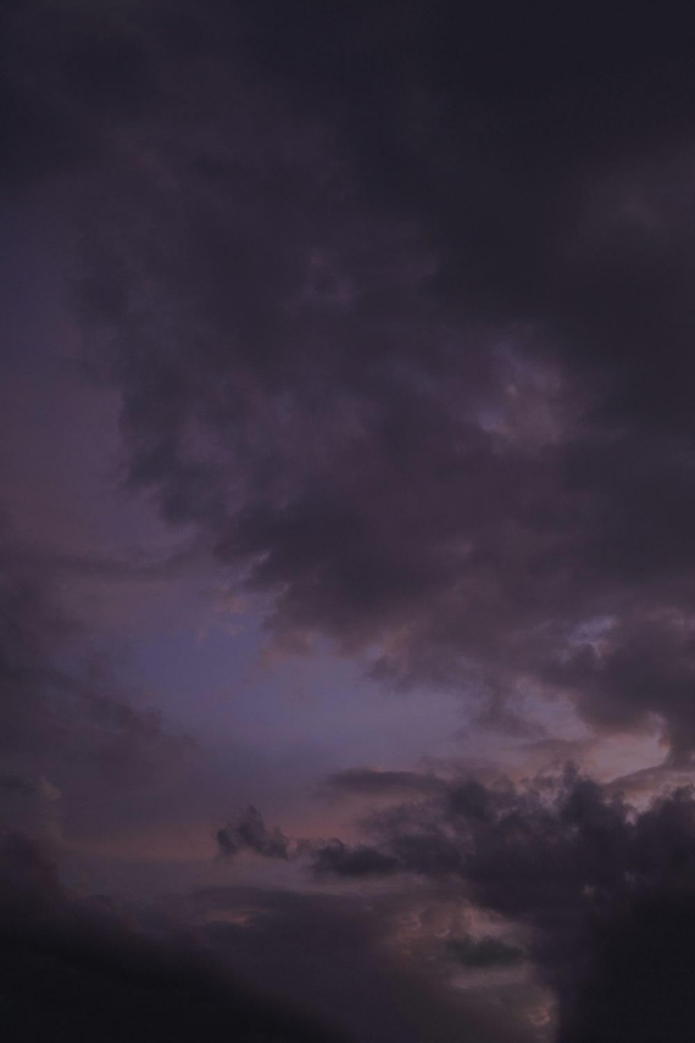 a plane flying through a cloudy sky at night