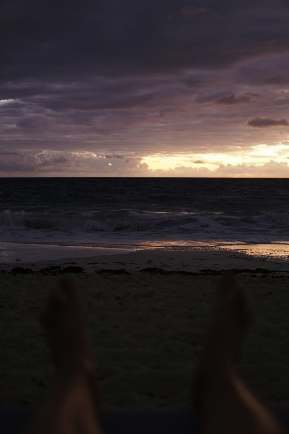 a person laying on a beach next to the ocean