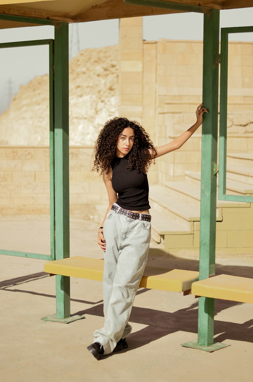 a woman posing for a picture in front of a bench