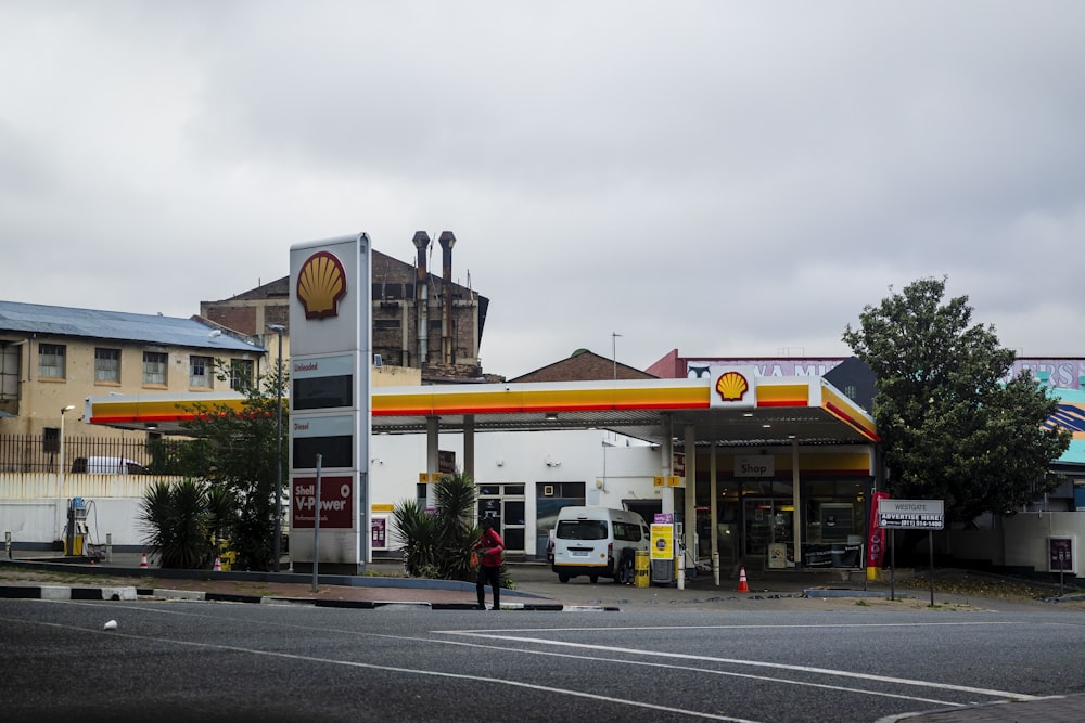 a gas station with a person standing in front of it