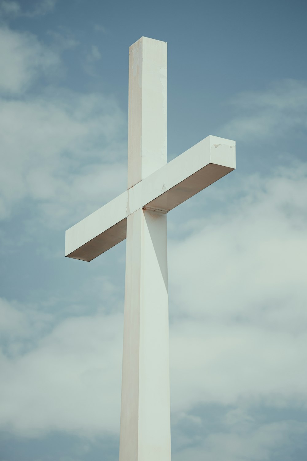 a large white cross with a sky background
