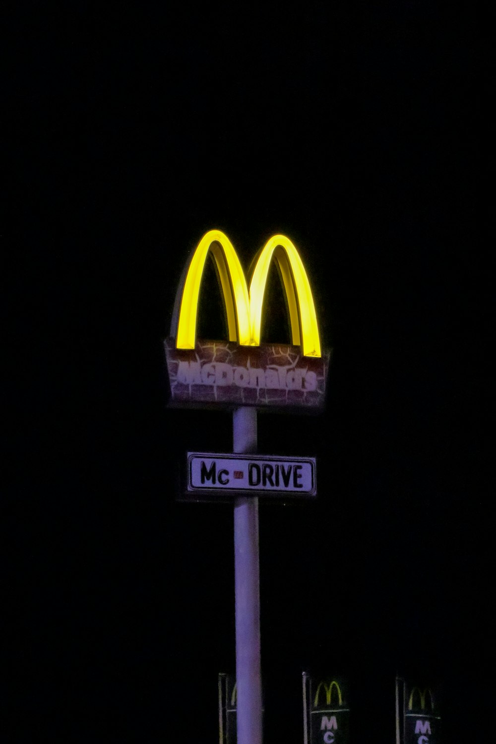 a mcdonald's drive sign lit up at night