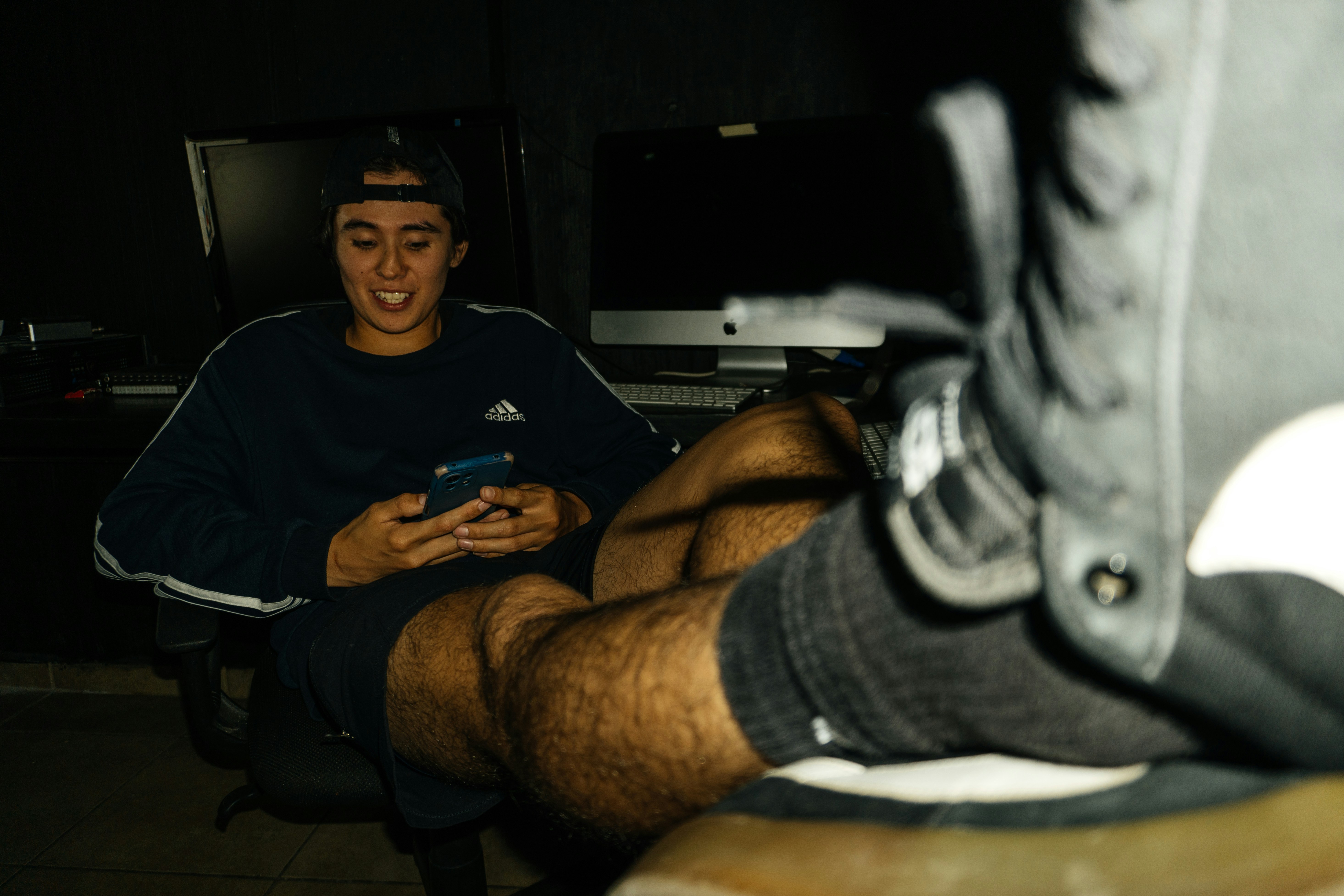 a man sitting in a chair looking at his cell phone