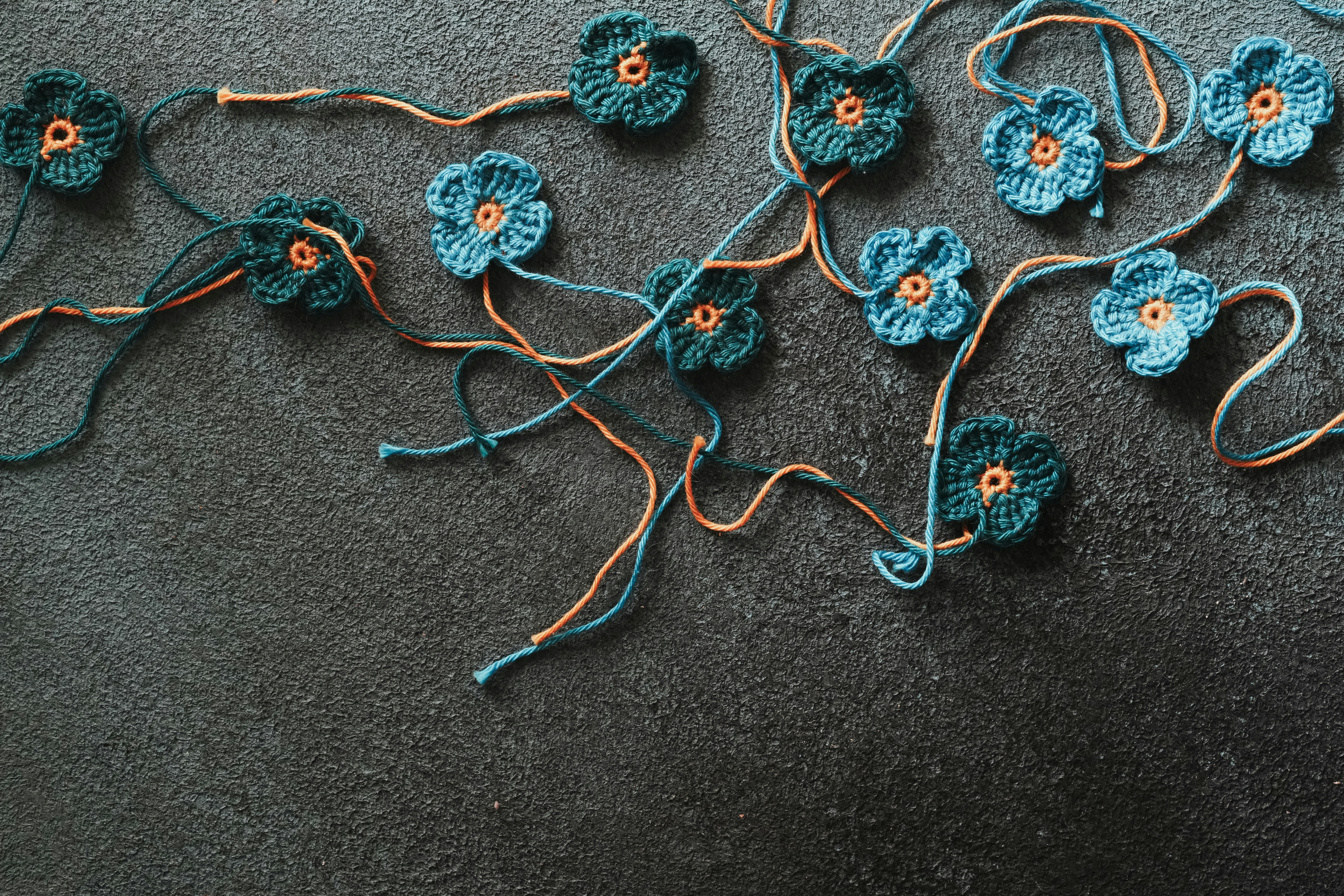 a group of crocheted flowers laying on the ground