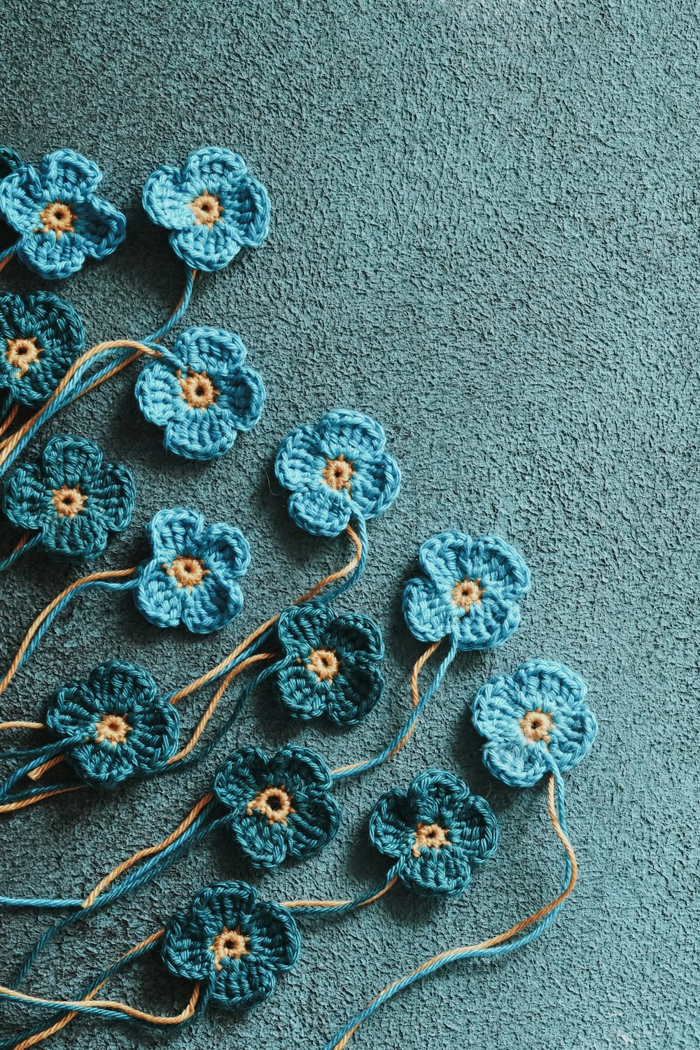 a group of crocheted flowers sitting on a blue surface
