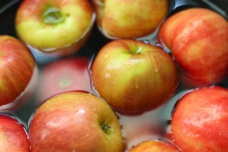 a group of red and yellow apples floating in water