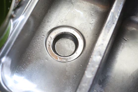 Close-up of a stainless steel grease trap showing its polished surface and sturdy construction.
