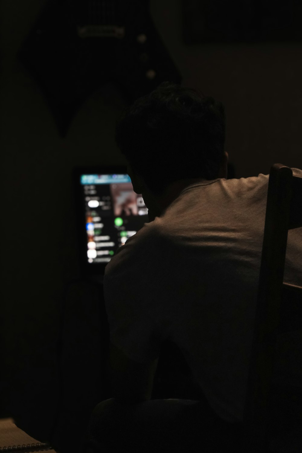 a man sitting in a chair in front of a laptop computer