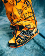Close-up of a vibrant urban sneaker on a graffiti-covered wall.
