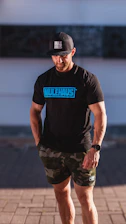 Close-up of a person wearing a stylish mulah merch plus t-shirt, smiling confidently outdoors.