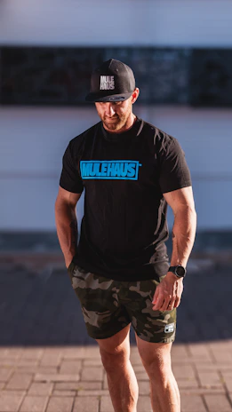 Close-up of a person wearing a stylish mulah merch plus t-shirt, smiling confidently outdoors.
