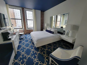 Interior of a sleek, minimalist hotel room with floor-to-ceiling windows overlooking the sea.