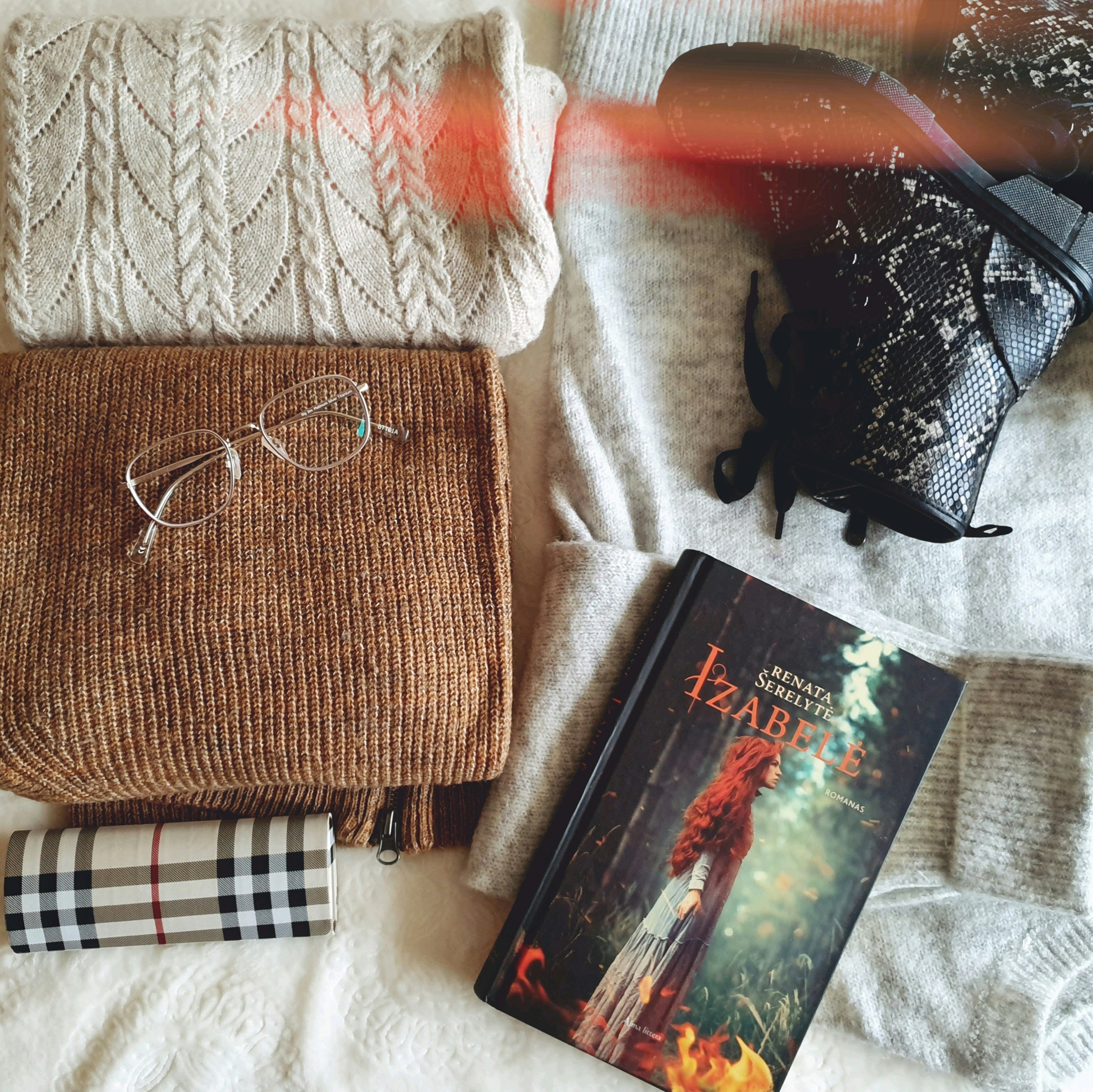 a book and a pair of glasses on a bed