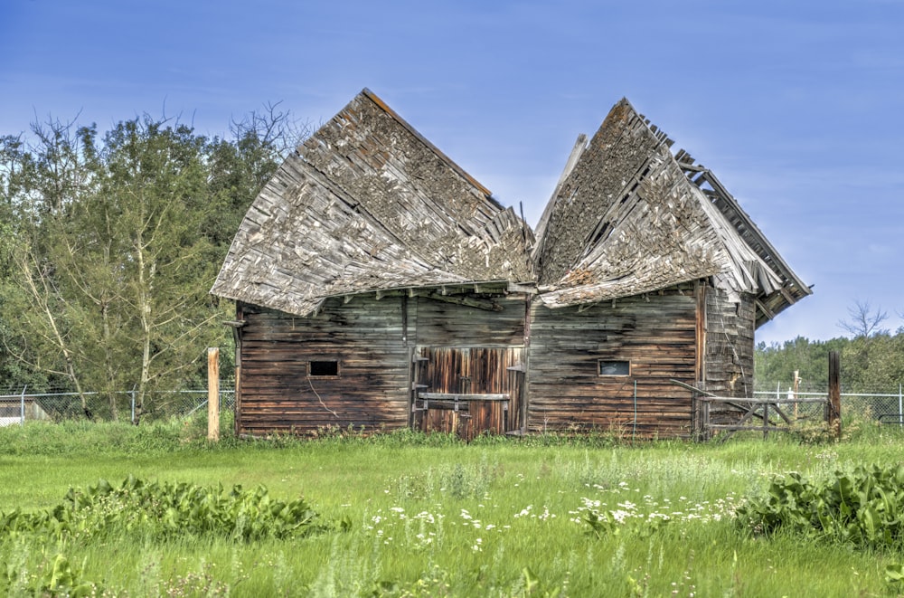 an old wooden house in a grassy field