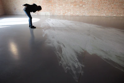 Close-up of a smooth, glossy epoxy floor being applied in a modern industrial warehouse.