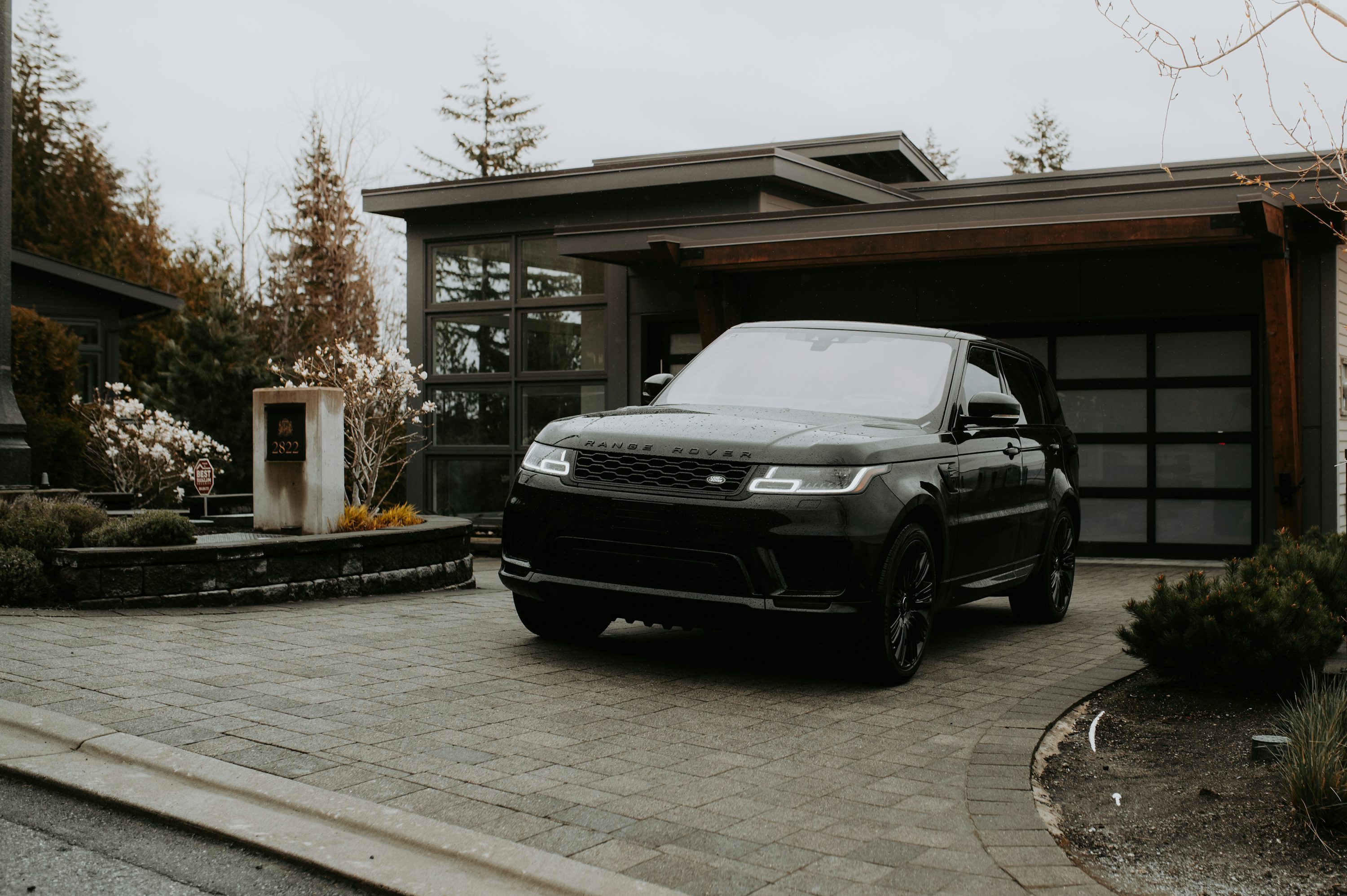 a black range rover parked in front of a house
