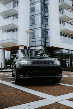 Sleek black Range Rover parked at airport terminal under soft evening lights.