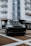 A sleek black Range Rover parked in an urban setting with city buildings in the background.