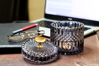 A warm, inviting workspace with a phone, notebook, and a jar of golden ghee on the desk.