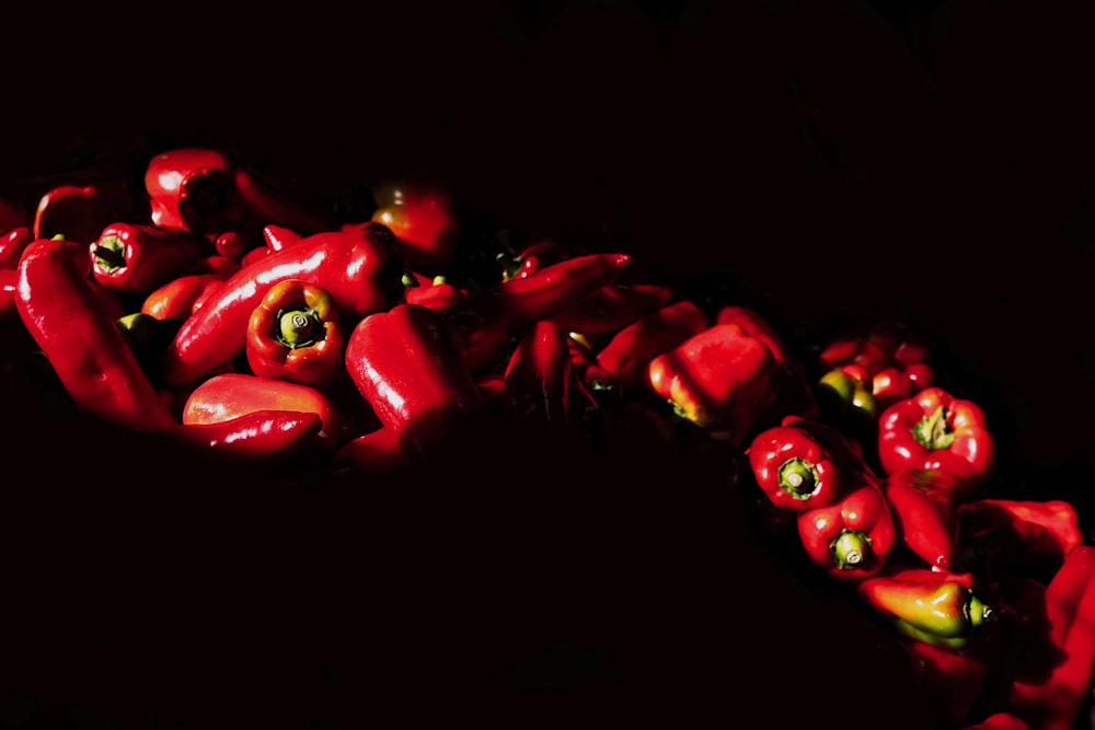 eine Gruppe roter Paprika auf schwarzem Hintergrund