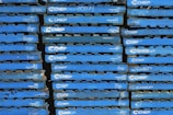 A stack of blue wooden pallets marked with the brand name 'CHEP' in white letters. Each pallet is uniformly colored and arranged tightly together, forming a repetitive pattern.