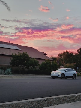 A certified golf cart parked on a quiet neighborhood street at sunset.
