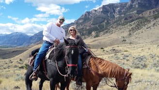 Smiling travelers enjoying horseback riding on a sunny day in the sierras.