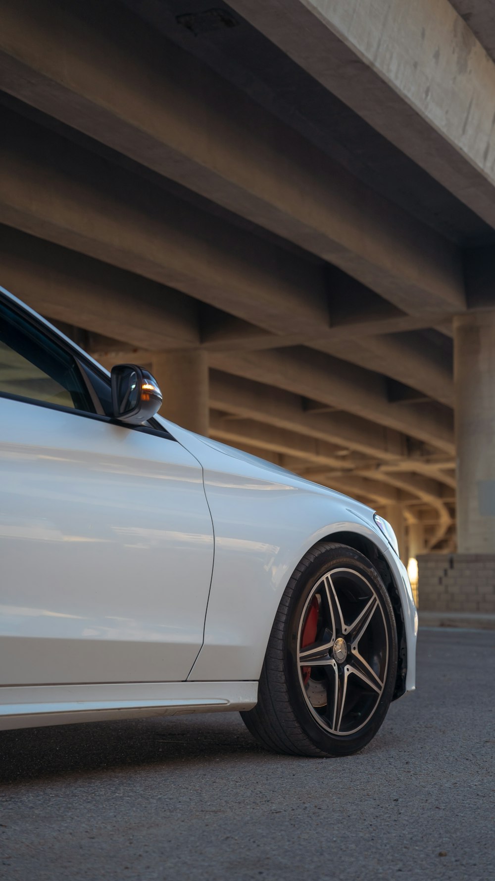 a white car parked in front of a bridge