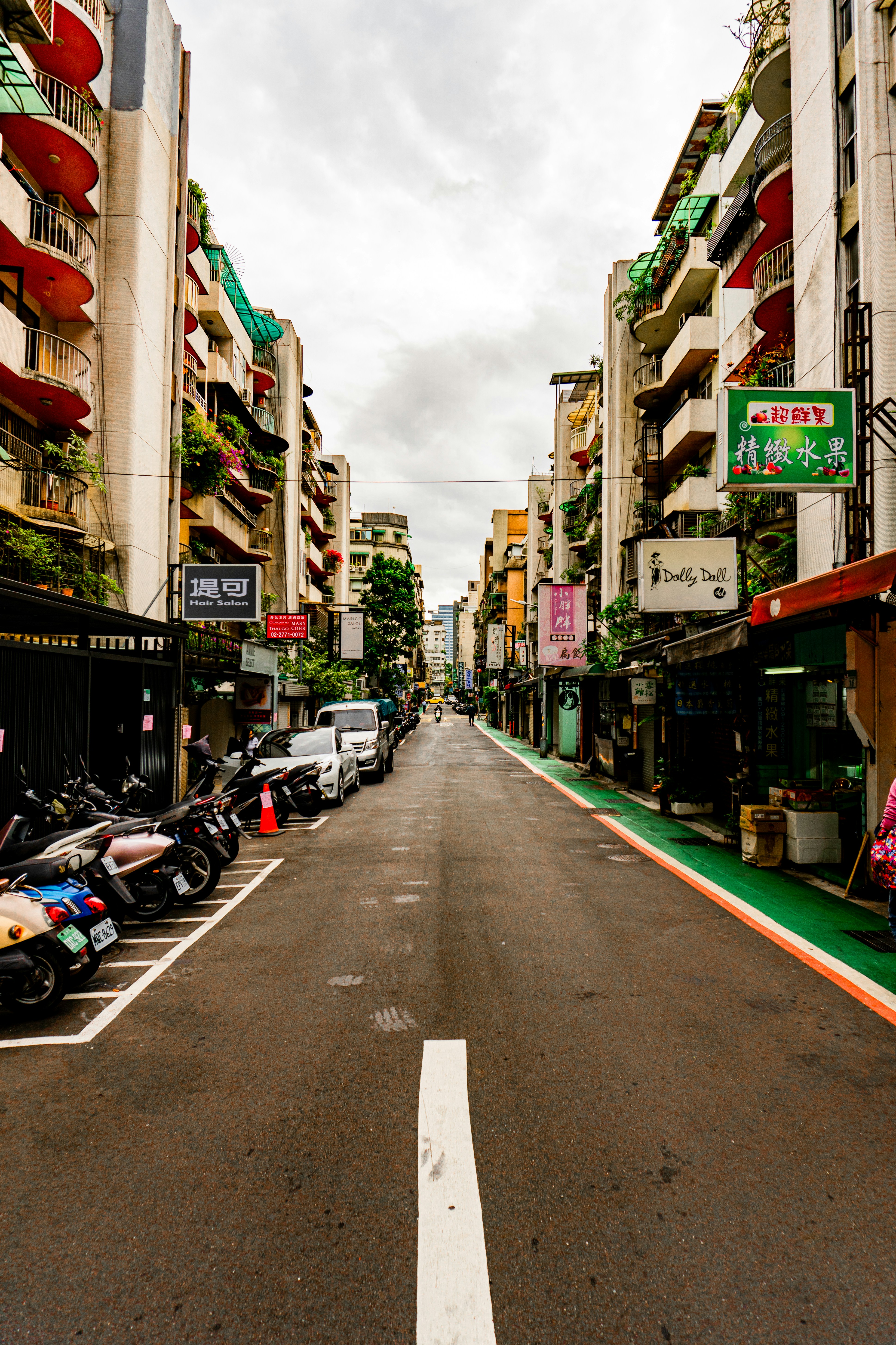 a street lined with parked motorcycles next to tall buildings