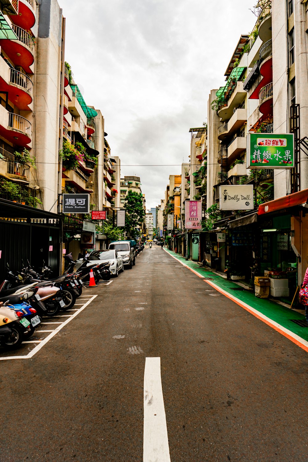 a street lined with parked motorcycles next to tall buildings