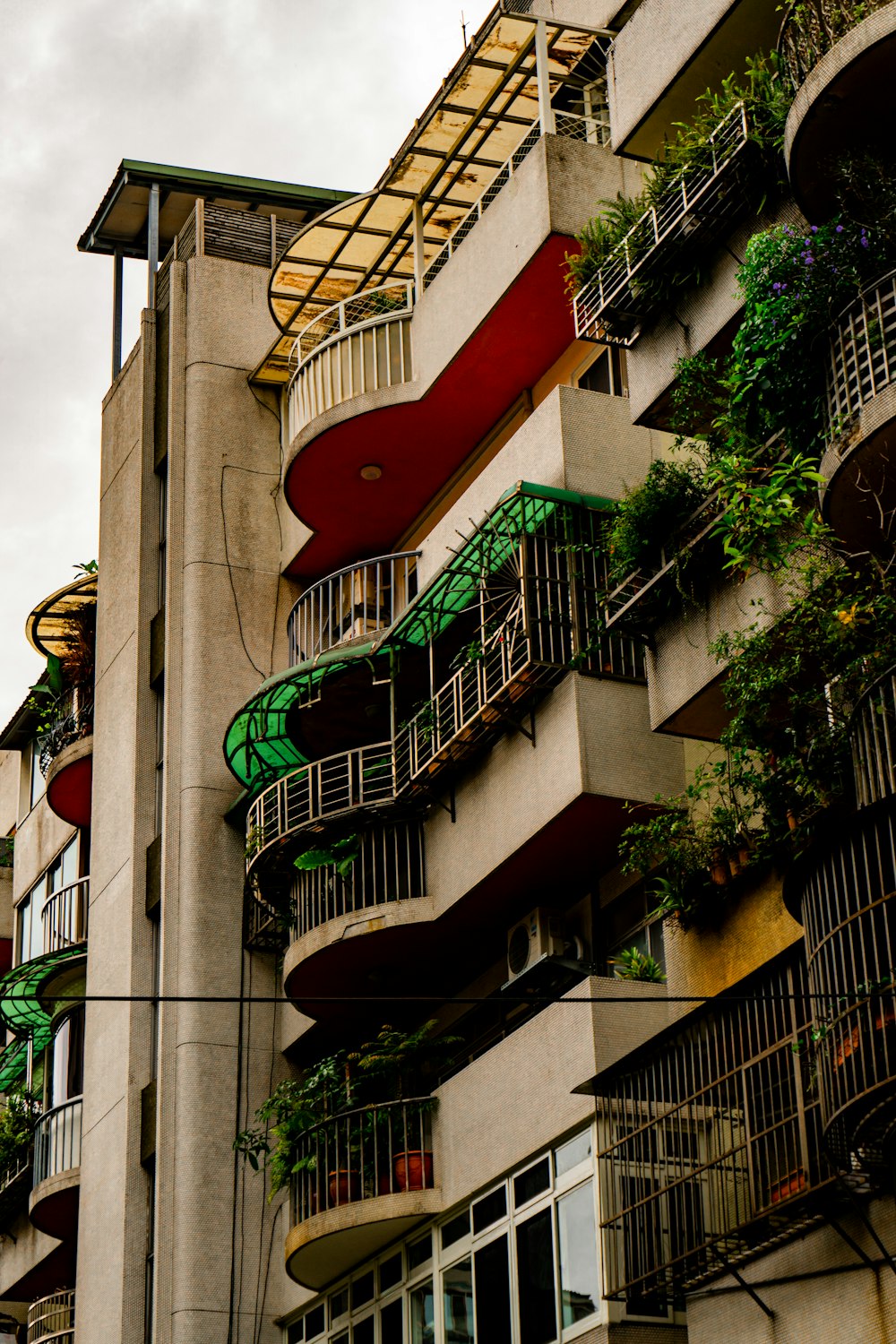 a tall building with balconies and plants on the balconies