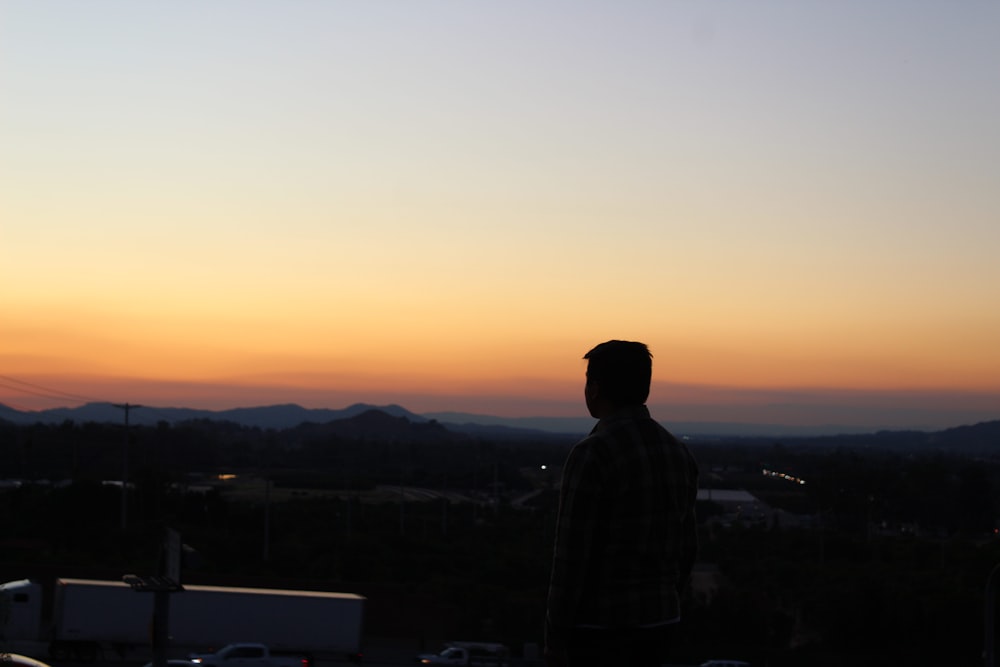 a man standing in front of a sunset