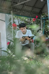 A young girl reading a book under a tree, symbolizing hope and learning.