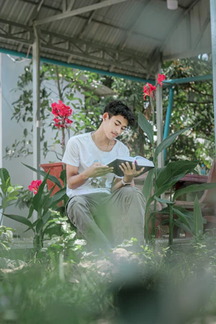 A parent and child reading the book together in a cozy garden nook surrounded by blooming flowers.