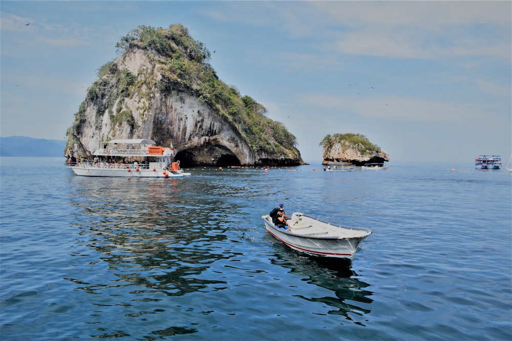 dois barcos na água perto de uma pequena ilha